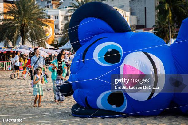 Child looks at a giant kite that has fallen out of the sky on February 26, 2023 in Pattaya, Thailand. Pattaya hosts the 'International Kite on the...