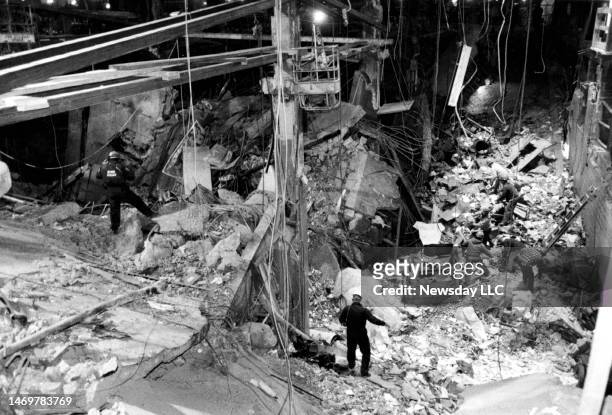Bomb Squad investigators on Feb. 28, 1993 work looking for evidence on a lower level ledge, as construction workers at the bottom remove rubble from...
