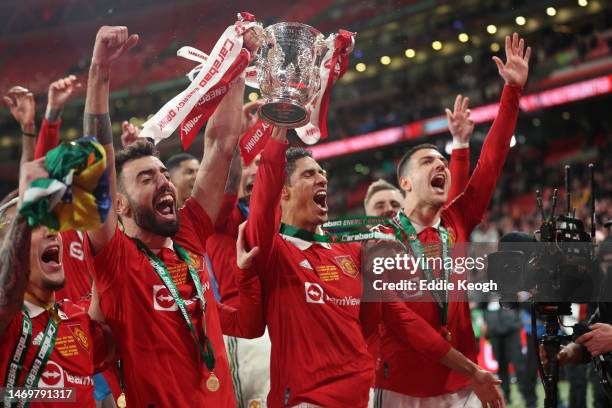 Bruno Fernandes and Raphael Varane of Manchester United celebrate with the Carabao Cup trophy following victory in the Carabao Cup Final match...