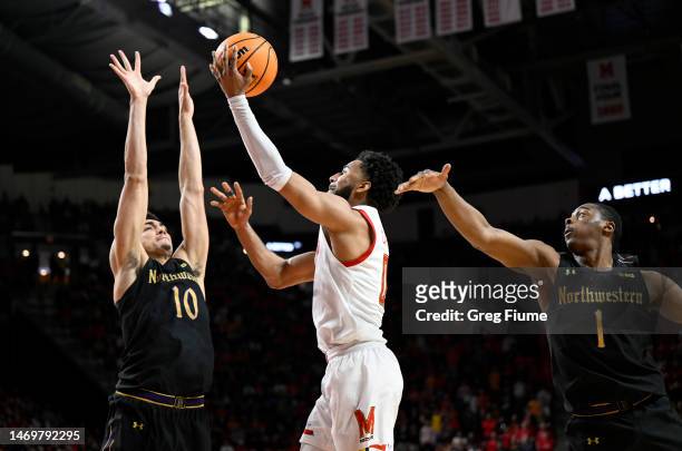 Don Carey of the Maryland Terrapins drives to the basket against Tydus Verhoeven and Chase Audige of the Northwestern Wildcats in the second half of...