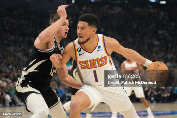 Devin Booker of the Phoenix Suns dribbles the ball against Grayson Allen of the Milwaukee Bucks in the first half of the game at Fiserv Forum on...