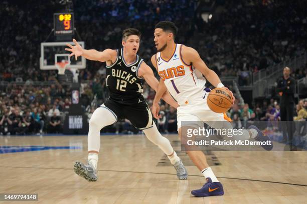Devin Booker of the Phoenix Suns dribbles the ball against Grayson Allen of the Milwaukee Bucks in the first half of the game at Fiserv Forum on...