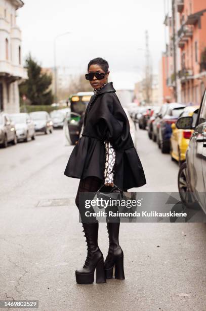 Guest is seen wearing long black boots, balck and silver turtle neck long sleeve top, silver bag, black sunglasses and black jacket outside the...