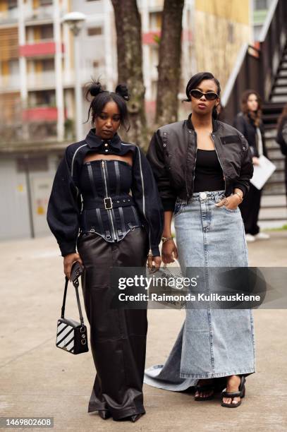 Guest is seen wearing long black leather maxi skirt,black and white bag, strapless black top, and seperately black sleeves, and a guest wearing long...