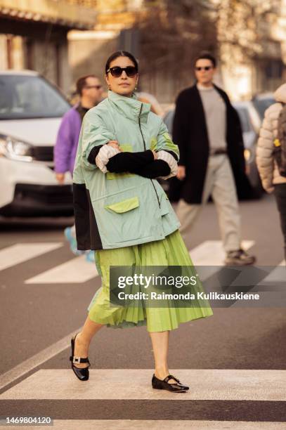 Caroline Issa is seen wearing light grass green pleated skirt, black shoes, and light blue, black, and green jacket outside MSGM during the Milan...