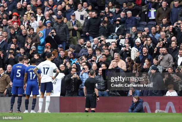 Players and fans watch as Referee Stuart Attwell checks the VAR screen during the Premier League match between Tottenham Hotspur and Chelsea FC at...