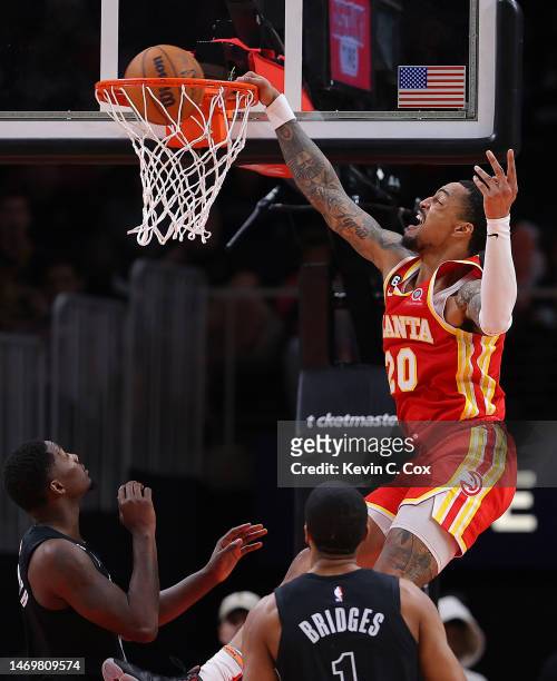 John Collins of the Atlanta Hawks dunks against Dorian Finney-Smith and Mikal Bridges of the Brooklyn Nets during the second quarter at State Farm...