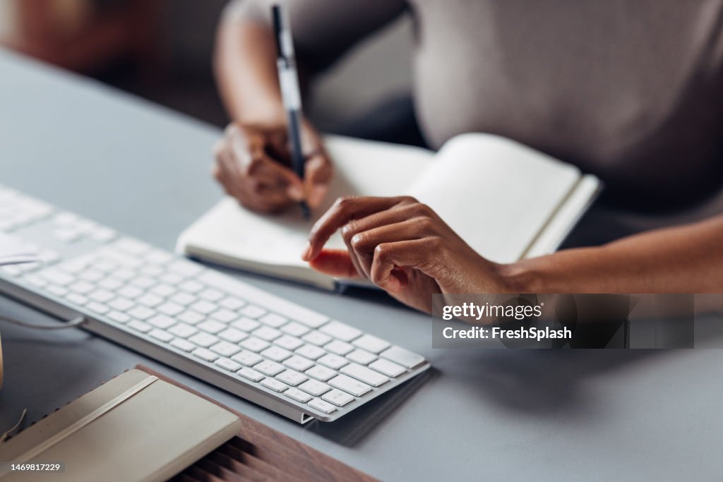 An Unrecognizable Businesswoman Taking Some Notes In Her Notebook