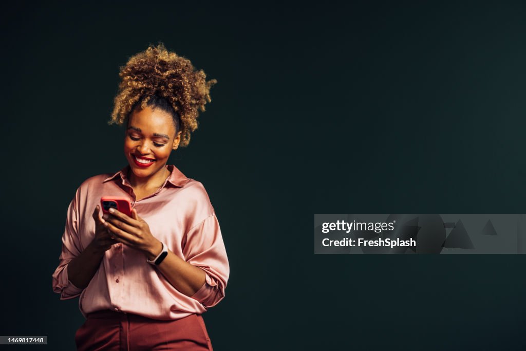 A Happy Beautiful Businesswoman With Blonde Curly Hair Texting On Her Mobile Phone