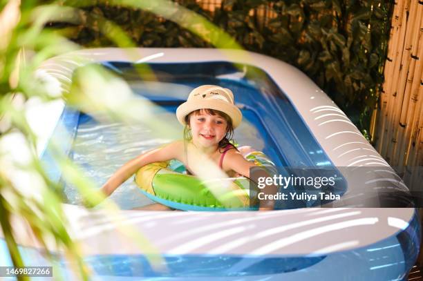 little girl in swimming pool on sunny day - plastic pool stockfoto's en -beelden