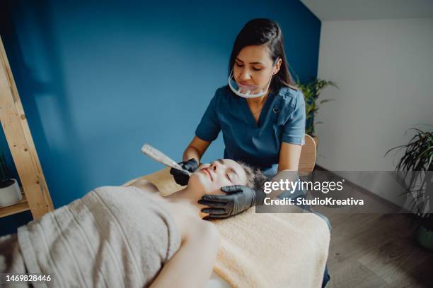 high-angle view of a female dermatologist doing a micro-needling treatment for her client while using a derma pen - beautician client stock pictures, royalty-free photos & images