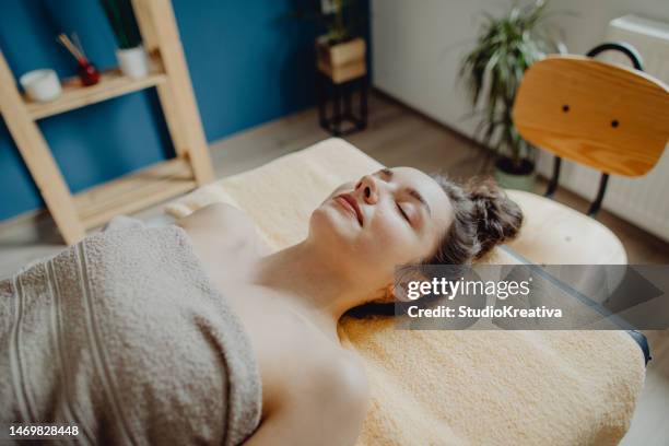 vista de alto ángulo de una mujer joven relajándose en el salón de belleza - massage room fotografías e imágenes de stock