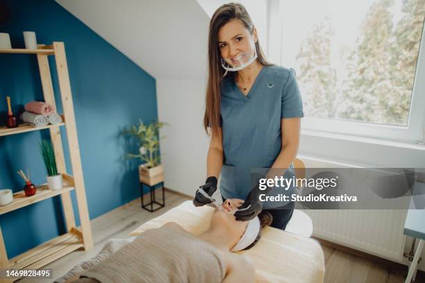 alegre dermatóloga haciendo un tratamiento de microagujas - odontología cosmética fotografías e imágenes de stock