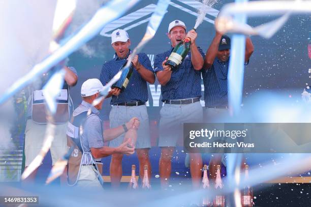 Anirban Lahiri, Paul Casey, Bryson DeChambeau and Charles Howell III and caddies of Crushers GC celebrate with the trophy on the podium after winning...