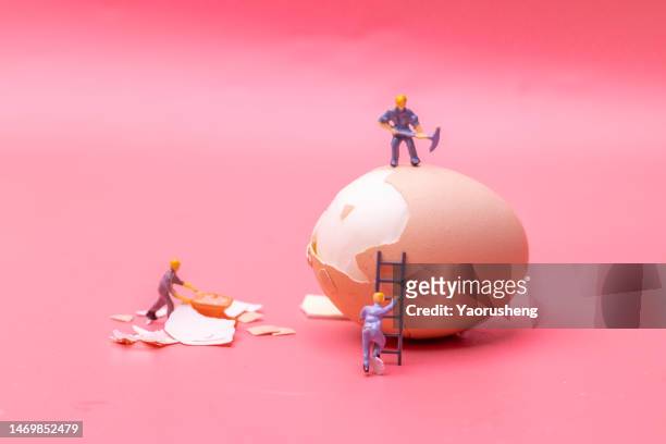 figurines work hard on the egg - miniatures stock pictures, royalty-free photos & images