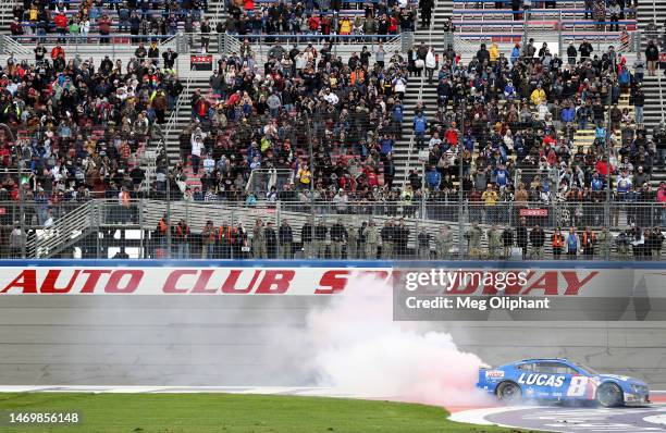 Kyle Busch, driver of the Lucas Oil Chevrolet, celebrates with a burnout after winning the NASCAR Cup Series Pala Casino 400 at Auto Club Speedway on...