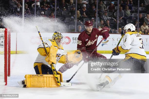 Goaltender Juuse Saros of the Nashville Predators makes a save as Christian Fischer of the Arizona Coyotes skates in during the second period of the...