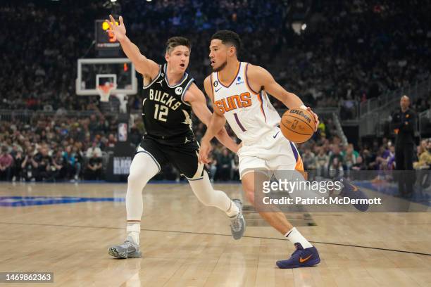 Devin Booker of the Phoenix Suns dribbles the ball against Grayson Allen of the Milwaukee Bucks in the first half at Fiserv Forum on February 26,...