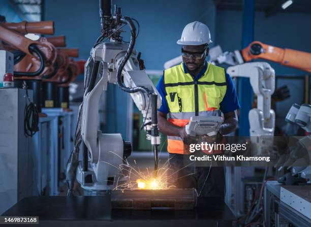 african engineers control robotic arc welding at production line of factory - produce fotografías e imágenes de stock