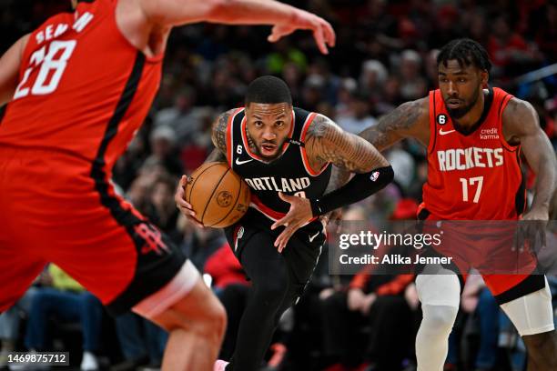 Damian Lillard of the Portland Trail Blazers drives to the basket against Tari Eason and Alperen Sengun of the Houston Rockets during the first...