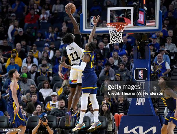 Naz Reid of the Minnesota Timberwolves goes up to slam dunk over Jonathan Kuminga of the Golden State Warriors during the third quarter at Chase...