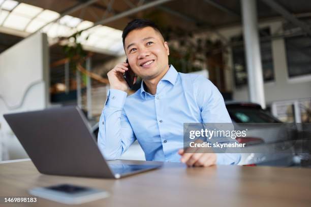confident car salesperson with crossed arms in a showroom. - car salesperson stock pictures, royalty-free photos & images