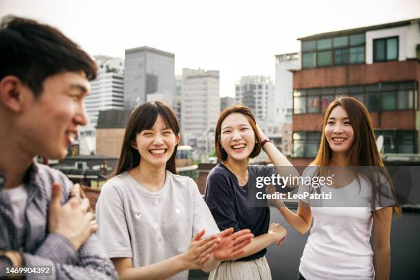 group of asians friends celebrate a birthday on a rooftop in downtown - jb of south korean stockfoto's en -beelden