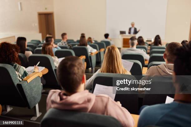 vista trasera de un gran grupo de estudiantes en una clase en la sala de conferencias. - aula de conferencias fotografías e imágenes de stock