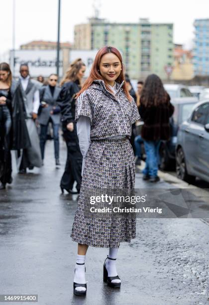 Christinna Kuan wear jacket with shirt sleeves, pleated skirt with print, white socks, button shirt, sandals outside Annakiki during the Milan...