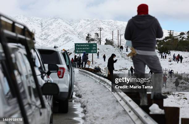 Cars are lined up after people parked on the side of the freeway to walk and play in the snow along Highway 14 in Los Angeles County on February 26,...