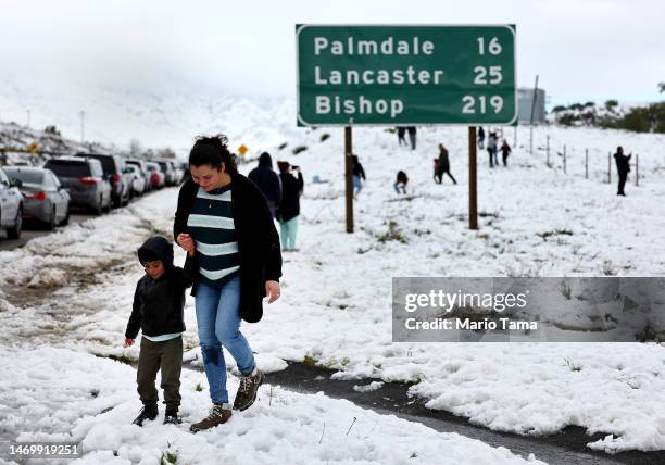 Cars are lined up after people parked on the side of the freeway to walk and play in the snow along Highway 14 in Los Angeles County on February 26,...