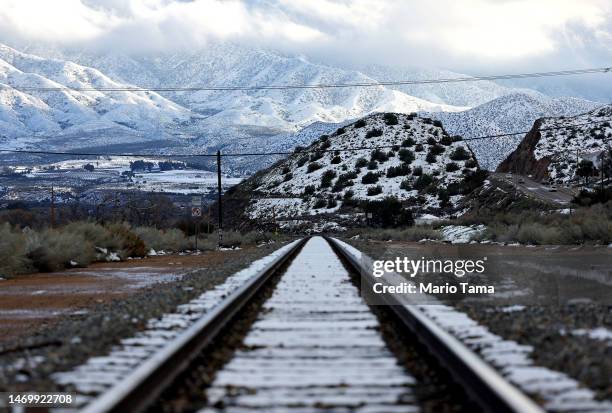 Snow-covered mountains and railroad ties are viewed in Los Angeles County on February 26, 2023 near Acton, California. A major storm, which carried a...