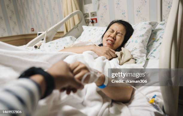 asian mother pregnant feeling pain and holding hand husband and waiting to give birth - giving birth fotografías e imágenes de stock