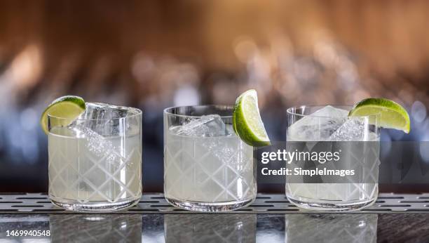 three margarita cocktails creatively prepared on the bar counter. - 酸っぱい ストックフォトと画像