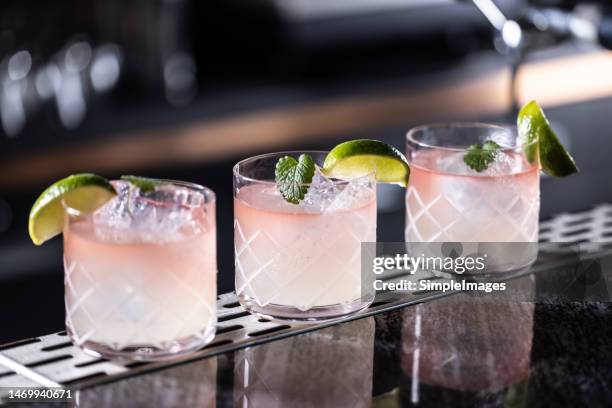 three margarita cocktails creatively prepared on the bar counter. - cocktail glass salt stock-fotos und bilder