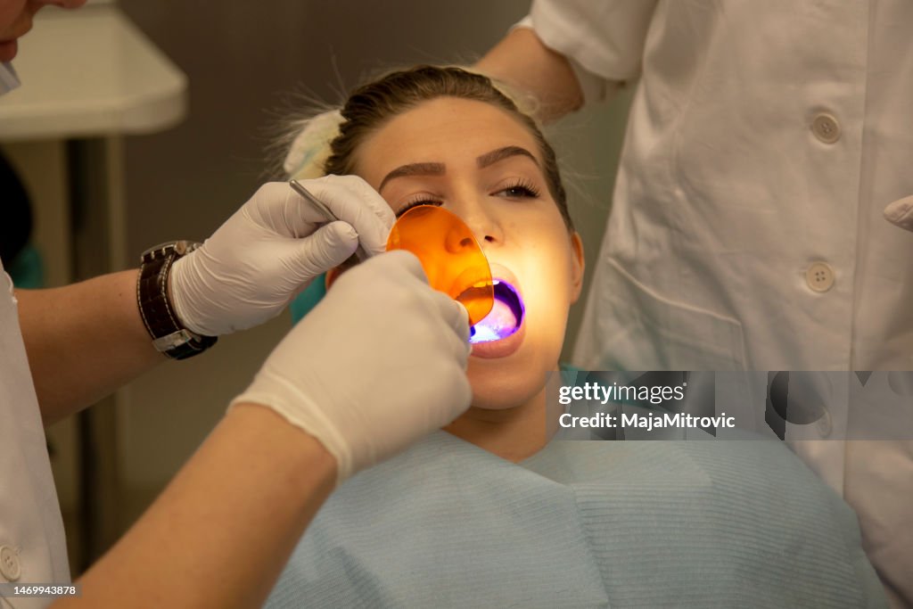 Young woman is getting treatment in dentist's office