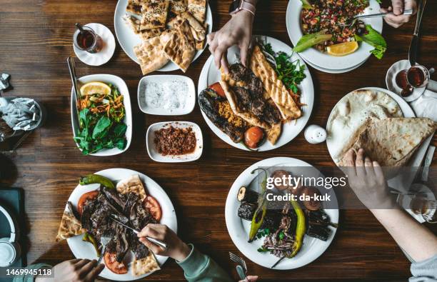 vista dall'alto del tradizionale cibo alla griglia turco con snack e verdure sul tavolo. persone che assumono vari alimenti - cucina del medio oriente foto e immagini stock