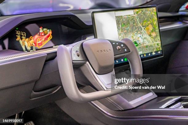 Tesla Model S full electric sedan interior with the yoke steering wheel and large touch screen on the dashboard at Brussels Expo on January 13, 2023...