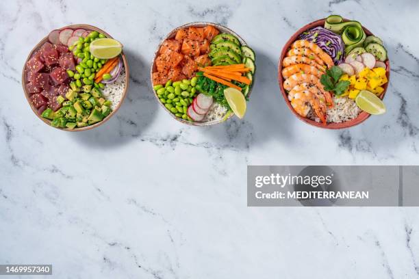 poke bowls, salmon poke, tuna poke and shrimp poke on white marble - salad bowl stock pictures, royalty-free photos & images