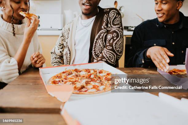 three young people open a box to reveal a full pizza - taste test stock pictures, royalty-free photos & images