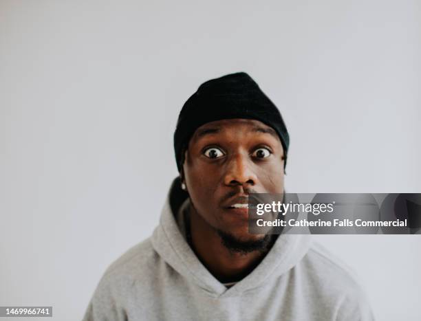 portrait of a handsome, young, black man, against a plain white backdrop. - genannt photos et images de collection