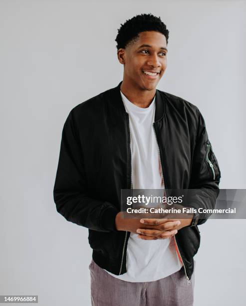 portrait of a handsome, young, black man, against a plain white backdrop. - black studio stock pictures, royalty-free photos & images