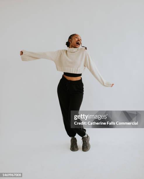a young black woman adopts various outgoing positions against a white backdrop, emulating performance, movement, dance or presenting - african woman full body isolated stock pictures, royalty-free photos & images