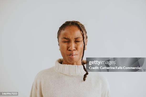 a young black woman pulls a silly face - puckering ストックフォトと画像