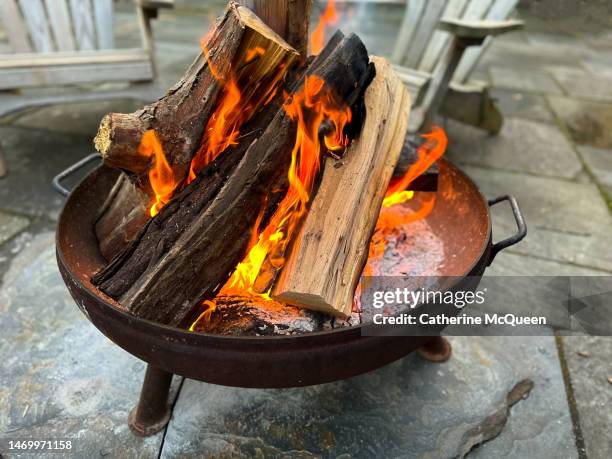 roaring fire in open outdoor fire pit - open fire place stock pictures, royalty-free photos & images