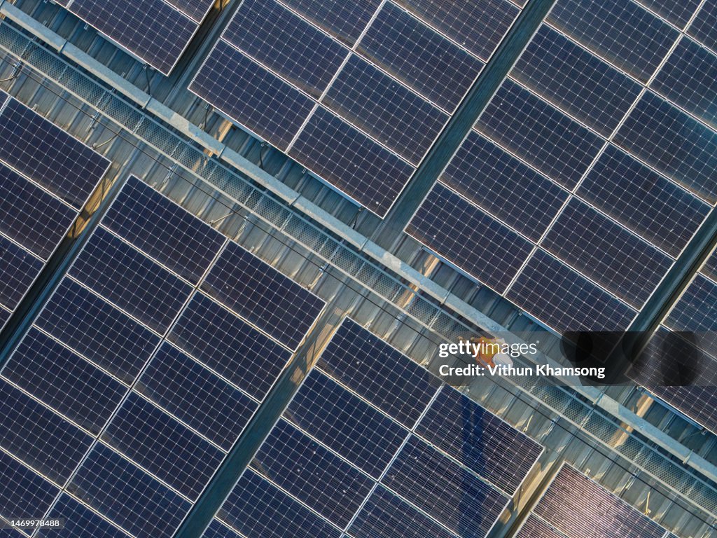 Aerial view of Engineers working at solar panels roof