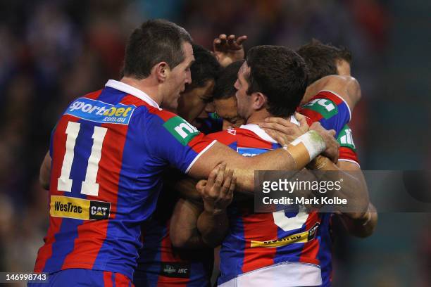 Timana Tahu of the Knights is congratulated by his team mates after scoring a try during the round 16 NRL match between the Newcastle Knights and the...