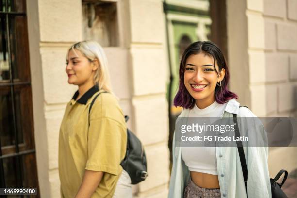 portrait of young woman walking with her friend through the city - alternative lifestyle stock pictures, royalty-free photos & images