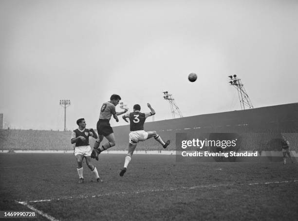 Irish footballer Noel Cantwell, West Ham defender, and British footballer Peter Broadbent, Wolves forward, vie for possession during the English...