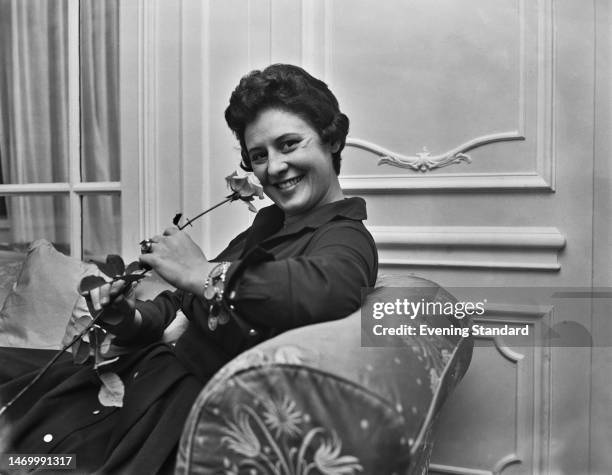 Bosnia-born Austrian opera singer Sena Jurinac, smiling as she poses sitting with a rose, London, England, 27th November 1959. Soprano Jurinac is...